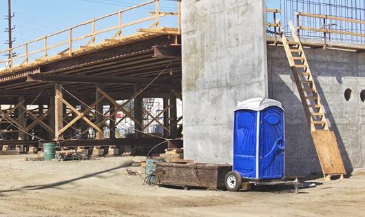 row of portable restrooms on a busy job site